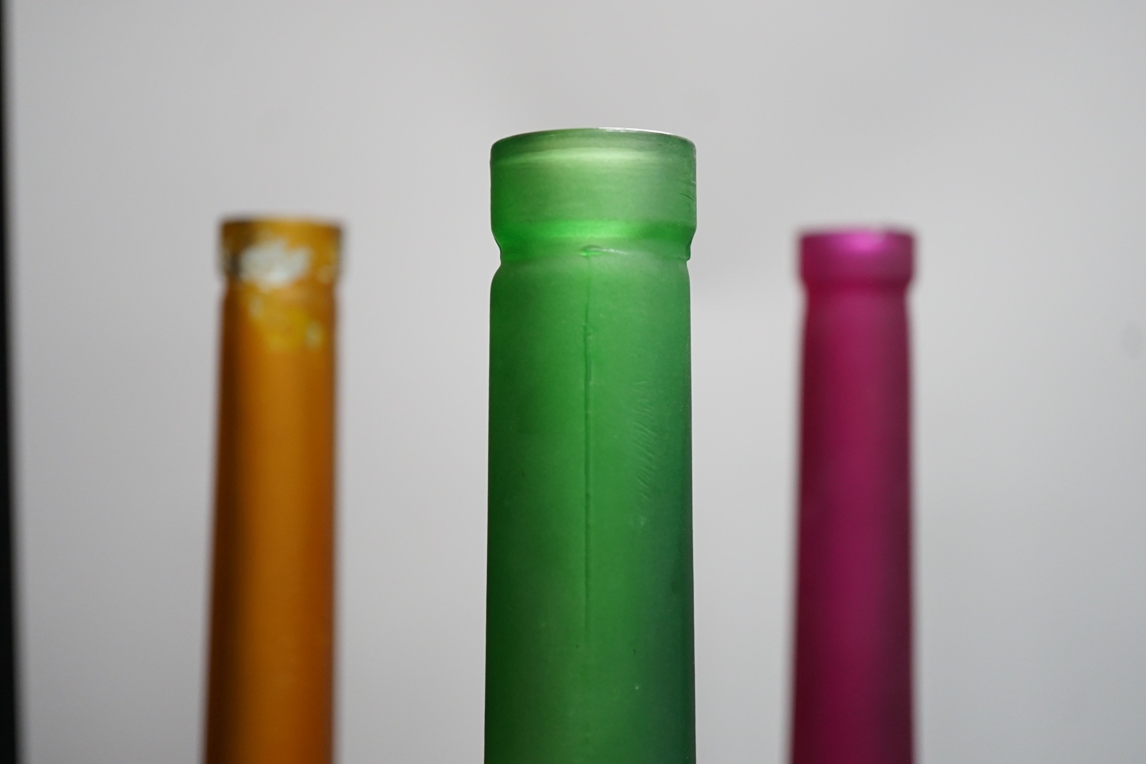 Five coloured glass bottle-neck vases, 42cms high